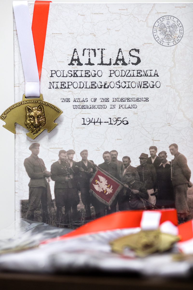 IPN's publication and the Wolf's Trail Run medal. Photo: Sławek Kasper (IPN)