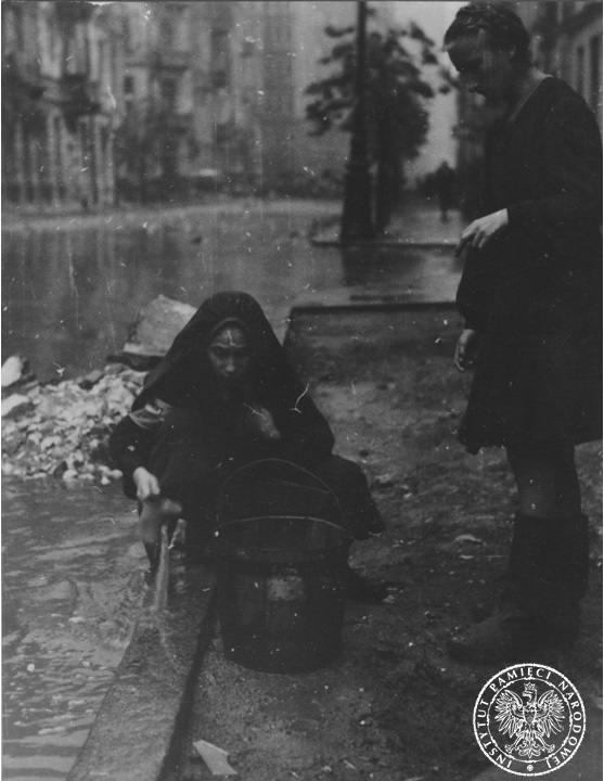 Women collecting water from the gutter